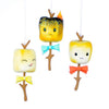 Image of Christmas three roasted marshmallow ornament on sticks with faces and bowties. One is happy, one has eyes closed and is licking its’ lips, and one is burnt with a bit of fire and a frowning face
